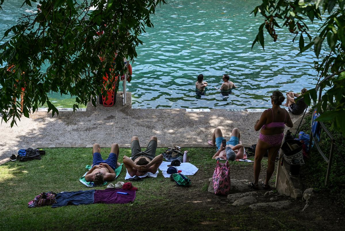 People cool off at Barton Springs as temperatures rose to 105° on July 13, 2022.