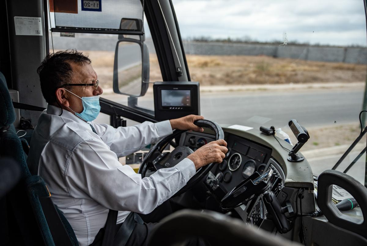 A bus driver drives towards the international bridge on Thursday, March 3rd, 2022 in Nuevo Laredo, Mexico. Workers from Nuevo Laredo were transported to the international crossing point to receive vaccines as part of a program where left over vaccines from the U.S. were to be used instead of being wasted or expiring. Sergio Flores for The Texas Tribune