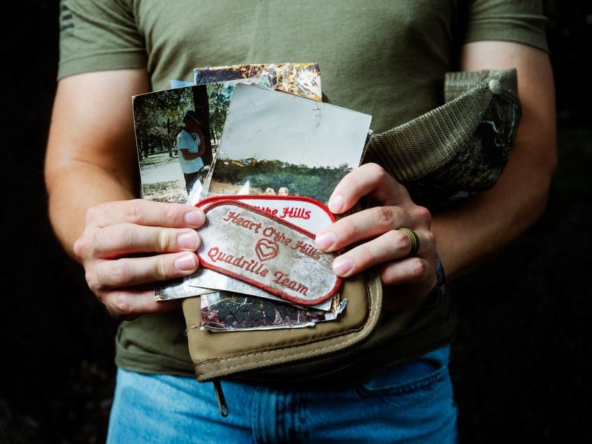 Michael Guyer holds photos and patches from the Heart of the Hills camp that he has found while volunteering in search efforts in the aftermath of the flood in Kerr County.