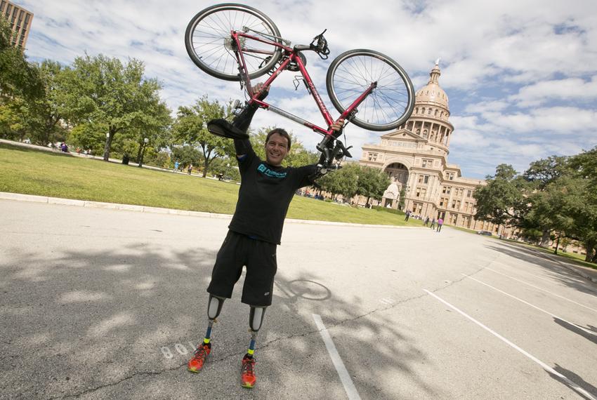 Carlos Gutierrez holds up his bike in front of the Texas Capitol on November 9th, 2013 after a 12 day bike ride across Texas.