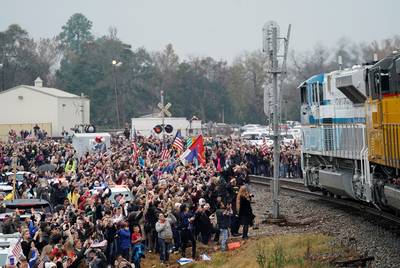 People pay their respects as the train carrying the casket of former President George H.W. Bush passes by along the route from Spring to College Station on Thursday, Dec. 6, 2018.