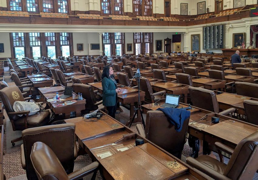 State Rep. Nicole Collier, D-Fort Worth, talks on the phone from the floor of the nearly empty House chamber on on Aug. 18, 2025. Collier is staying in the chamber because she did not want to sign the required permission slip allowing lawmakers to leave the Capitol under escort by Department of Public Safety agents.