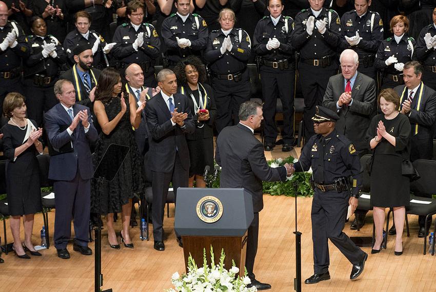 Dallas Mayor Mike Rawlings shakes Chief of Police David Brown's hand as former President Bush, President Obama, their wives, U.S. Sens. Cornyn and Cruz and others applaud on July 12, 2016.