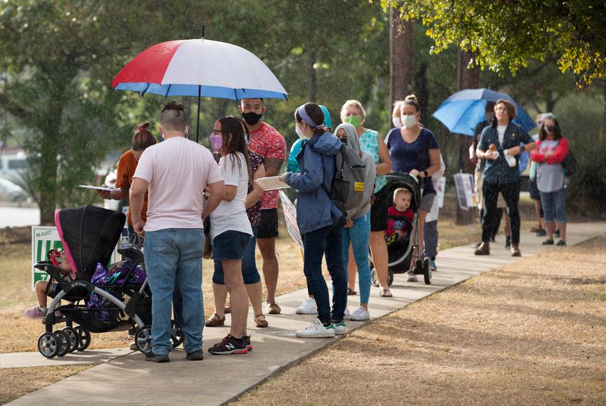 Bexar County residents stand in the early morning rain outside the Julia Yates Semmes Library on Oct. 20, 2020. The library was one of 48 polling locations within the county, however, compared to other major cities, there was no indication of the wait times given to voters to plan for the shortest line.