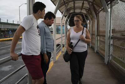 Immigration attorney Jodi Goodwin talks to Bernardo and Grisber Calero on the Mexican side of the international bridge in Reynosa on Sept. 15, 2018.