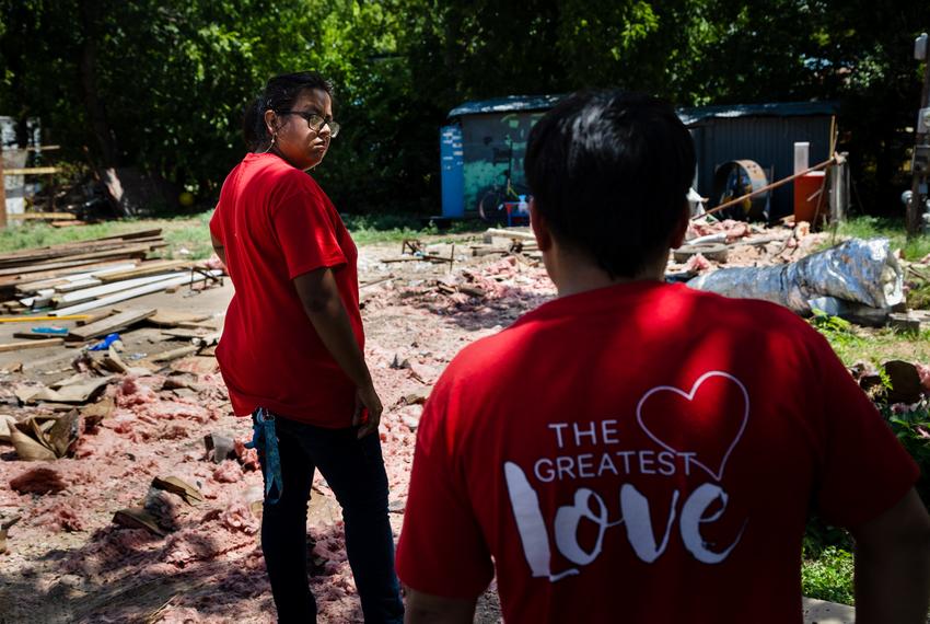 Paola Valdez-Lopez and her husband Edvin Agular look out over the remaining debris left behind after moves took their mobile home out of Congress Mobile Home Park in Austin on Aug. 29, 2022.