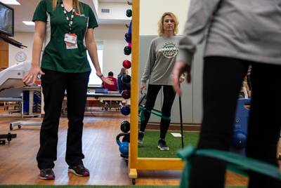 Flo Rice works out her legs by using resistance bands in a balance and hip strengthening exercise. Having been shot in both legs, Rice attends therapy 3-4 times a week to improve strength and stability.