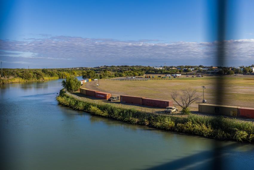 A row of shipping containers and razor wire placed on the banks of the Rio Grande River by Gov. Greg Abbott to form a makeshift border wall in Eagle Pass on Nov. 19, 2021.