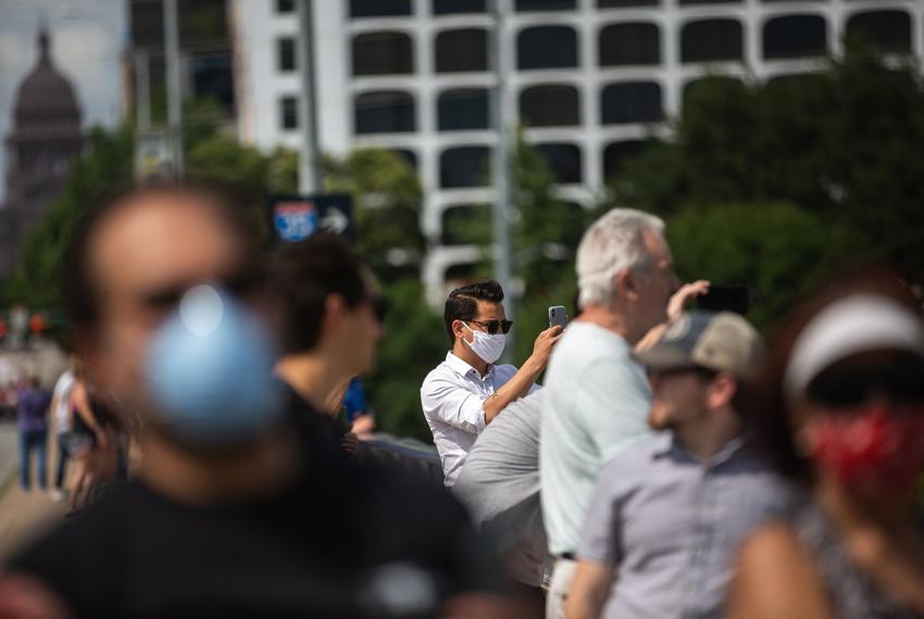 Austin residents take photos on Congress Avenue bridge in Austin on May 13, 2020. 