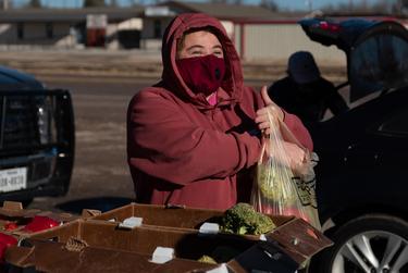 Marfa resident Ellie Tejada gathers produce from the Marfa Food Pantry Saturday morning. Tejada didn't have power at her house for three days this week and had to throw out her food.