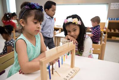 Cattleya Covarrubias (left) helps Aryana Huerta with a lesson at East Texas Montessori Prep Academy.