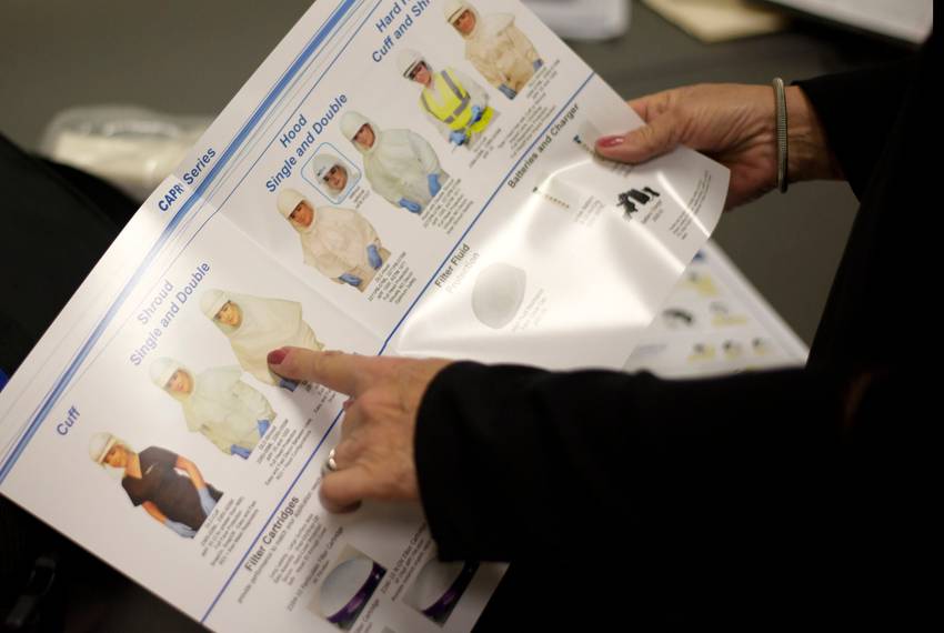 An attendee looks through different types of hoods during a personal protection equipment training session in Houston on M...