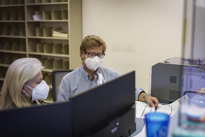 Jeffrey Warnken, R.Ph., right, and his wife Sandra Warnken R.Ph. organize vaccine paperwork at 38th St. Pharmacy in Austin on Jan. 7, 2021.