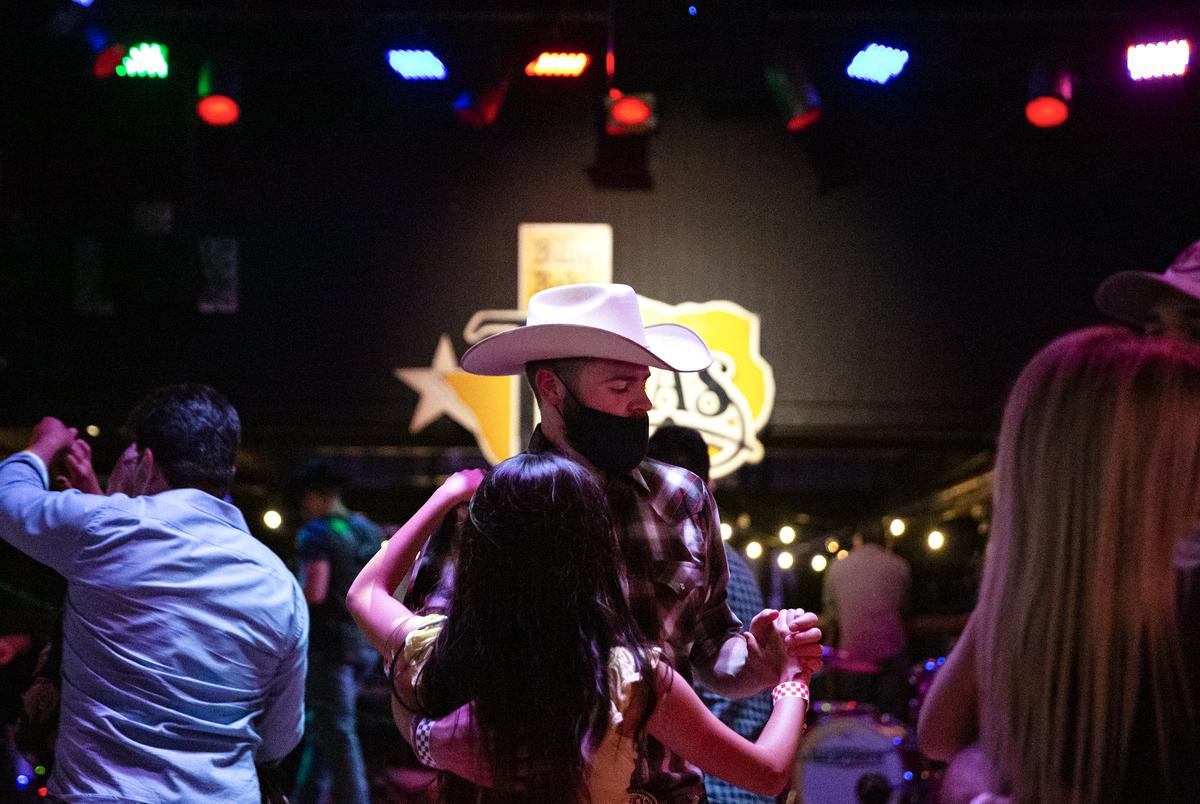 Guests dance at Billy Bob’s Texas, a honky-tonk in Fort Worth. Billy Bobís has been operating since August 13 under food and beverage guidelines after previously being classified as a bar. Bars that did not already get the food and beverage license were allowed to reopen October 14 at 50% capacity, and must stop selling alcohol by 11 pm.
