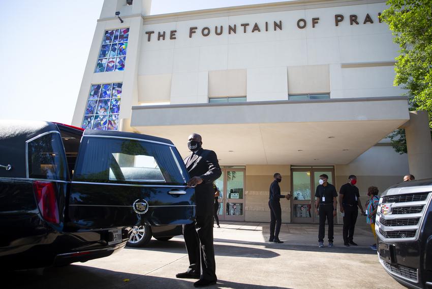 A man closes the back door of a hearse in preparation for the public memorial service honoring George Floyd at the Fountain of Praise Church in Houston on June 8, 2020.