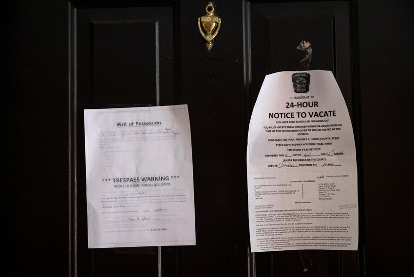 A writ of possession and a notice to vacate are taped to the door at an apartment complex in Houston on April 11, 2023.