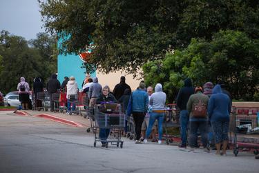 Shoppers lined up outside H-E-B before it opened one day in March. The COVID-19 outbreak caused the grocery chain to shorten its store hours in order to restock its inventory.