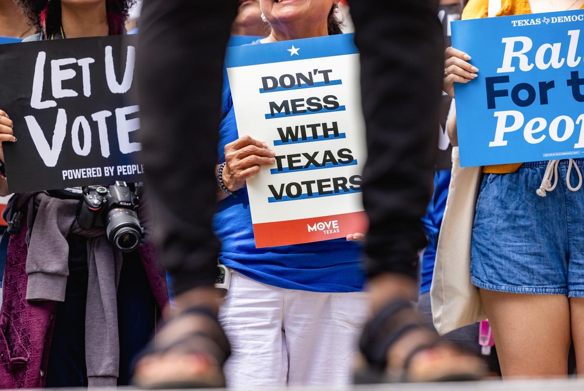 People hold Campaign signs at the ‘For the People’ voting rights rally on the south steps of the Texas Capitol on Sunday June 20, 2021.