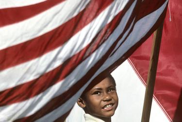 A young boy carries an American flag at a Juneteenth celebration in Austin. 