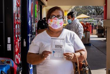 Maria Gilberta Reyna poses with her COVID-19 vaccine appointment information at a registration event in Irving on March 19, 2021.