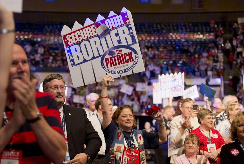 Delegates wave Dan Patrick posters advocating a more secure border on the Texas Republican Convention floor on June 7, 2014.