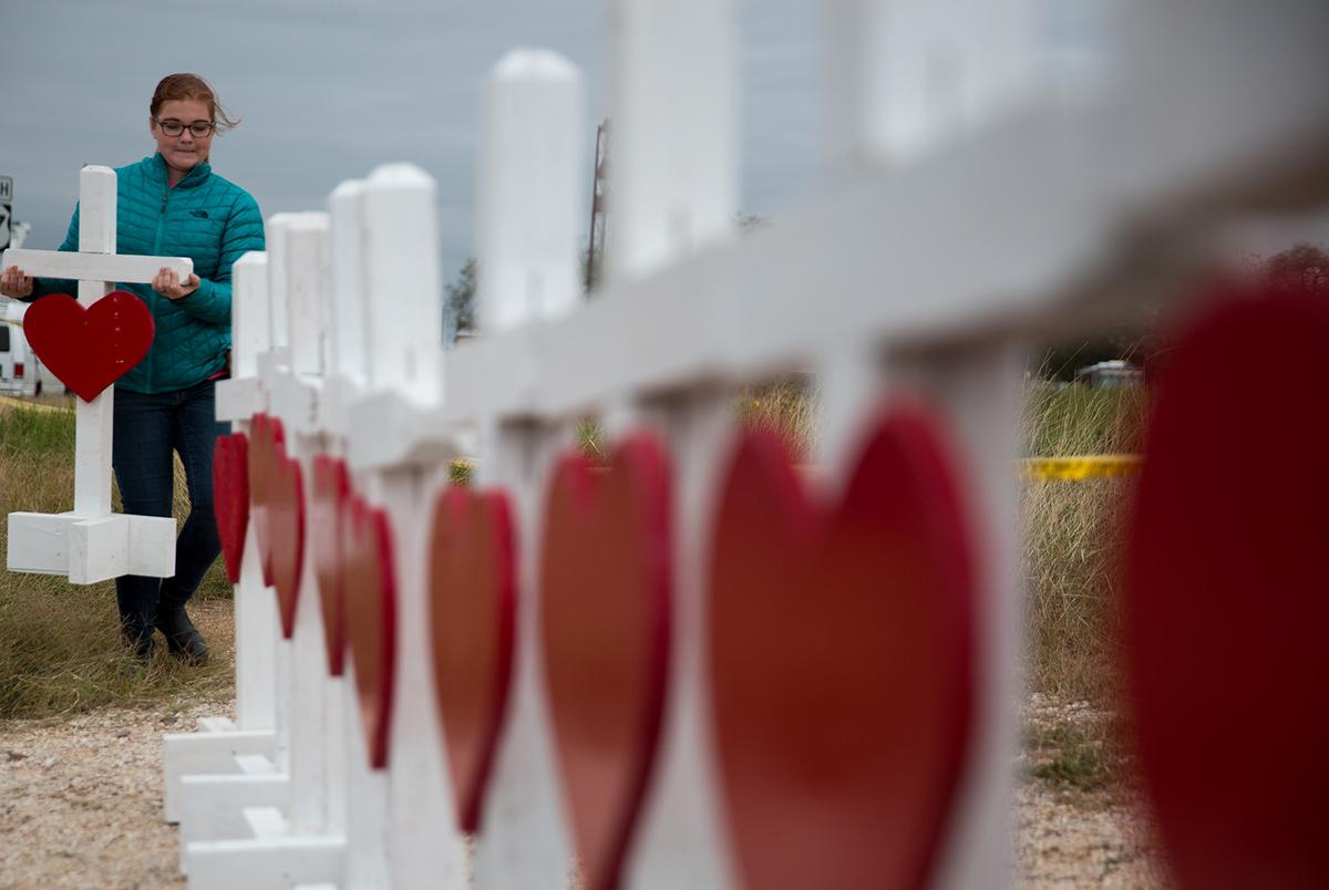 Hannah Krueger adds a cross to a memorial near the First Baptist Church in Sutherland Springs on Nov. 8, 2017, three days after 23 churchgoers were killed in a mass shooting there.