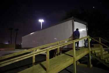 Juan Lopez waits to pick up a body from a refrigerated trailer at Doctors Hospital at Renaissance in Edinburg.