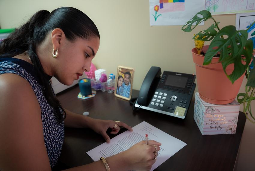 Katerin M.S., 24, a graduate student in social work at the University of Houston, works full time as a case worker while managing her schoolwork in her office. She edits a copy of her homework for a class on Critical Practice with Latinx Communities on her desk on Sunday, Aug. 17, 2025, in Houston.