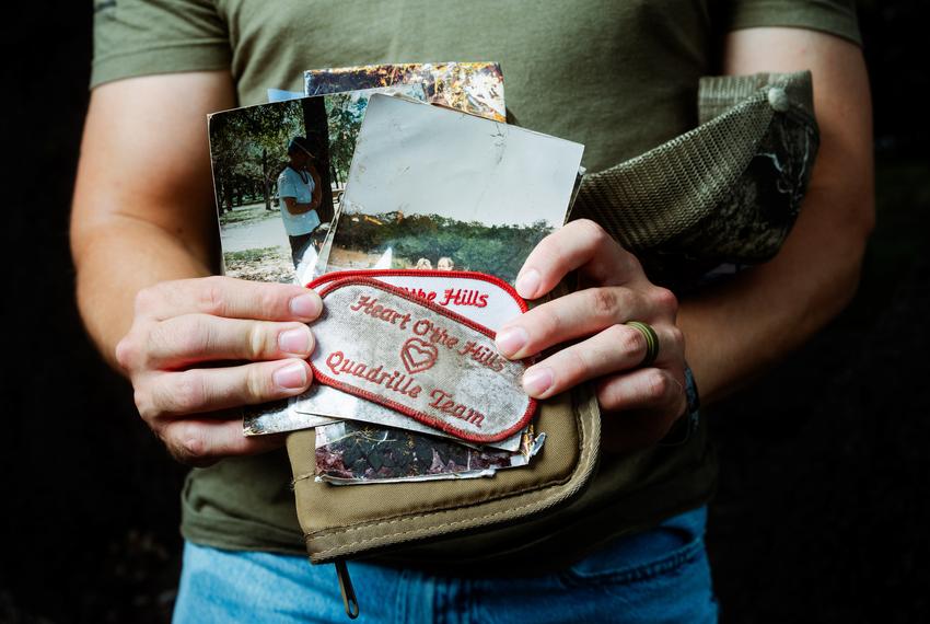 Michael Guyer holds photos and patches from the Heart of the Hills camp that he has found while volunteering in search efforts in the aftermath of the flood in Kerr County.