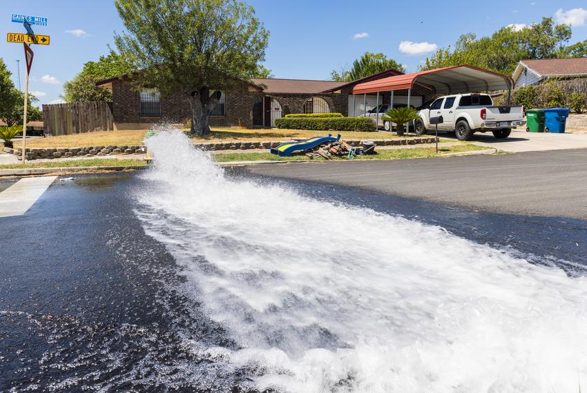 Water spews out of a fire hydrant as a San Antonio Water System crew works to fix a water main break near Hunt Ln. and Adams Hill in San Antonio, TX on August 18, 2022. 