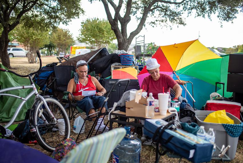 Adrian Elliot and Shirley Crawford sit near a former homeless encampment oN Riverside Drive on Sept. 28, 2021 in Austin. Many of the people who had been living in the camp said they weren't given enough notice and were not offered any place to stay.