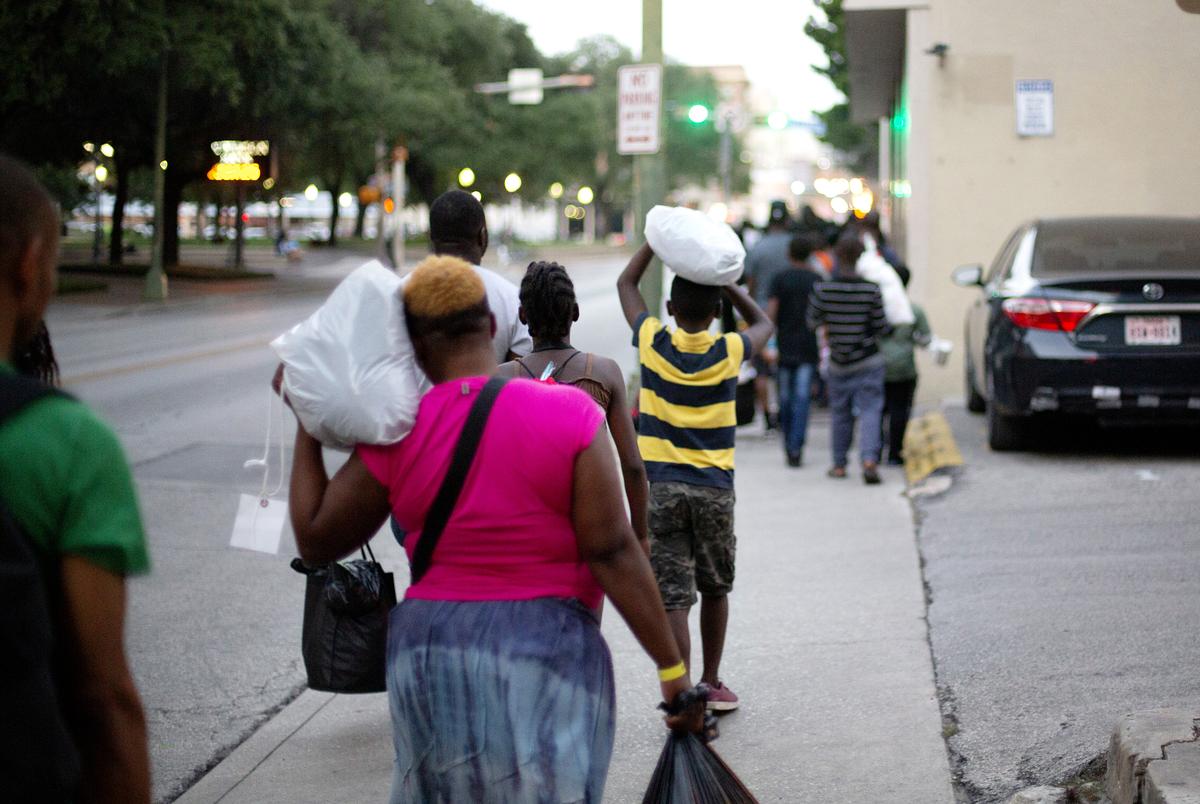 A group of migrants mostly from Africa walk a few blocks on June 26, 2019 from a makeshift processing center in downtown San Antonio to a shelter where they will spend the night. The shelter is run by the Interfaith Welcome Coalition.
