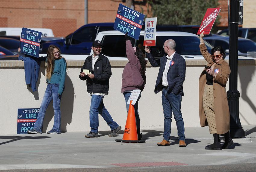 A voter walks past people campaigning for and against Proposition A in front of a polling location on Election Day in Amarillo.