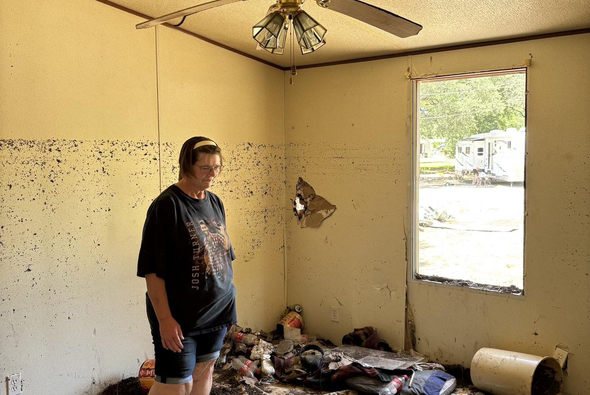 Tammy Roe stands in her former bedroom in the home of her step-father Harry Sherwood. “The mud was so thick in here and I shoveled it all outside trying to find my mom’s knicknacks,” she said. “That’s all I have left of my mom.”