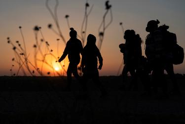 Asylum-seeking migrants' walked towards the border wall after crossing the Rio Grande into the United States from Mexico, in Penitas, Texas on March 26, 2021.  