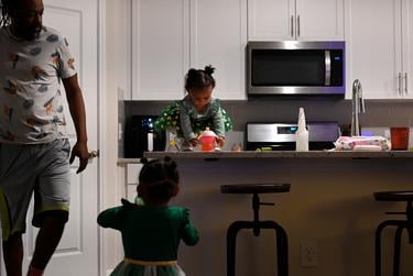 Kellani-Ari Wilson picks up her refilled sippy-cup on the kitchen counter in Manor, TX, on Feb. 2, 2023.