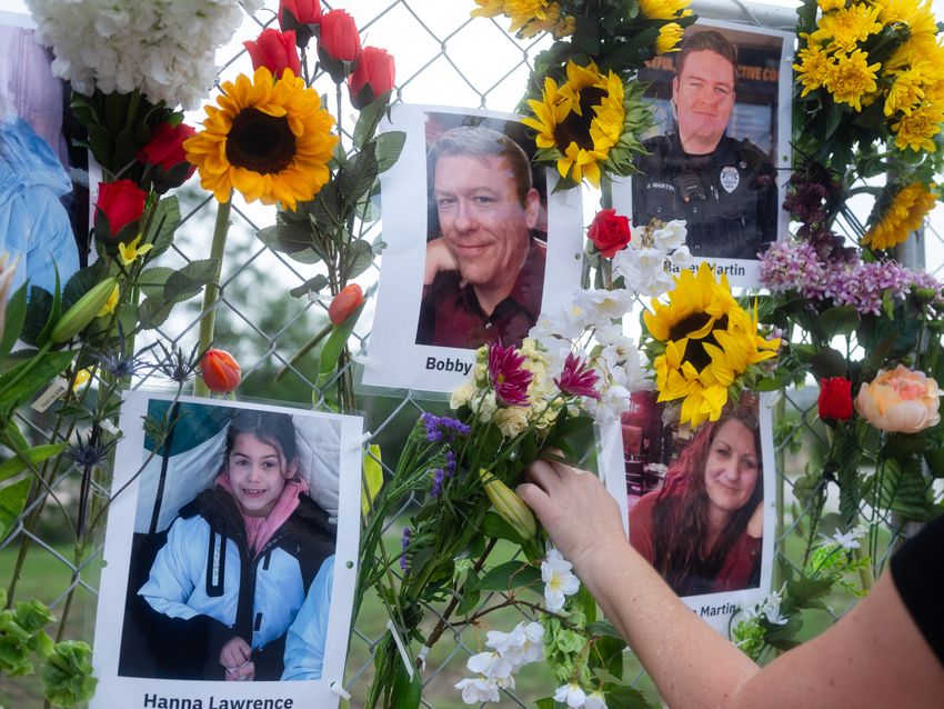 Community members add flowers to a memorial honoring victims of the flood in Kerrville, Texas on Wednesday July 9, 2025.