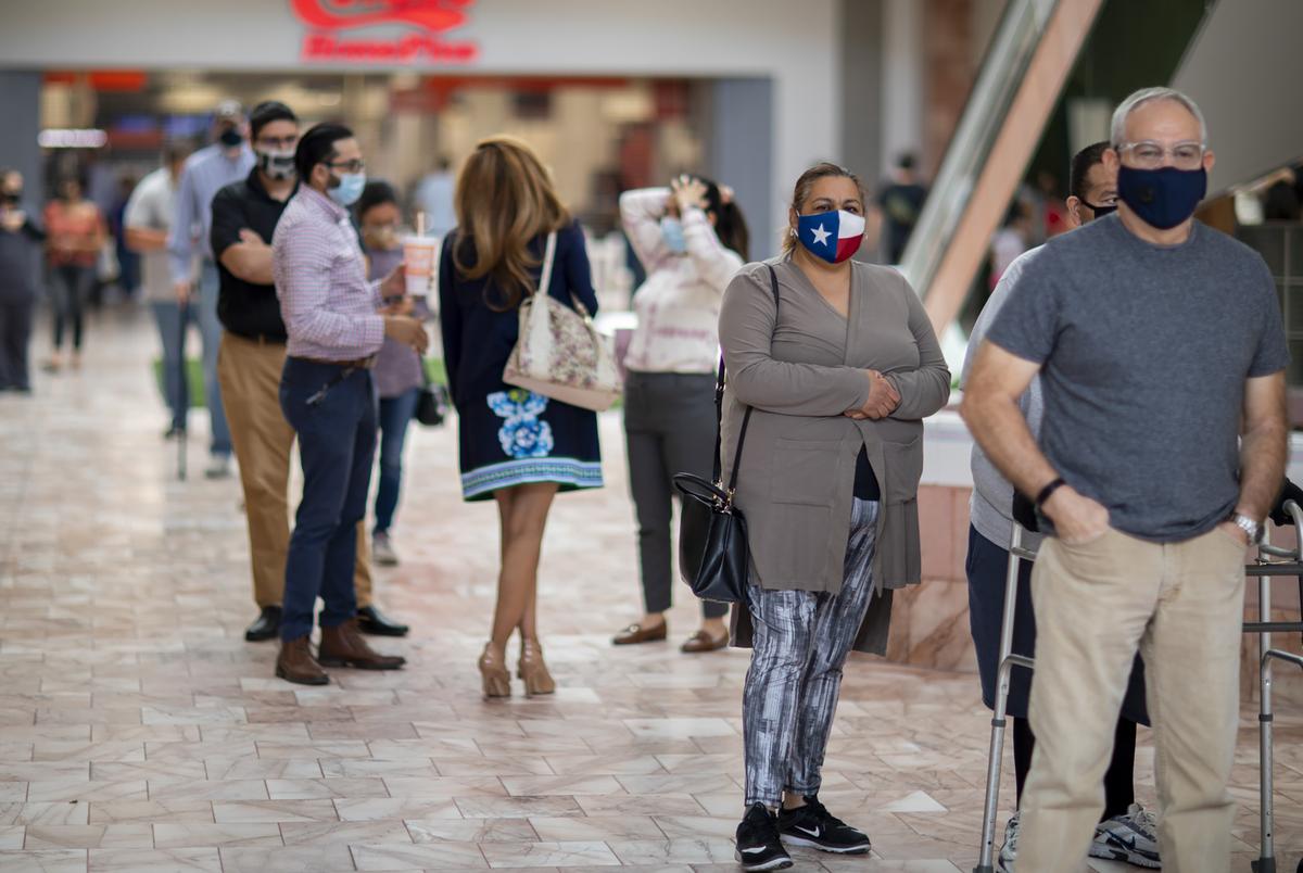 Voters wait in line to cast their ballots on day one of early voting in at the Sunland Park Mall indoor voting site in El Paso on Oct. 13, 2020.