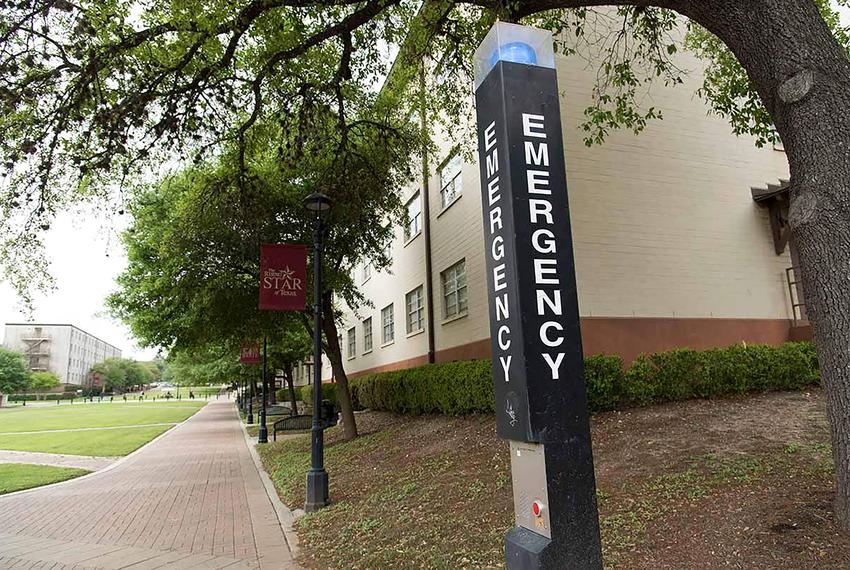 A blue-lit emergency call box on the Texas State University campus.