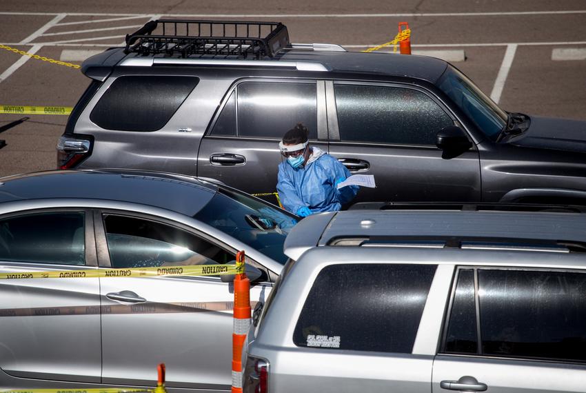 A medical personnel wears personal protective equipment while holding a COVID-19 test kit at a COVID-19 testing site at the University of Texas at El Paso on Nov. 19, 2020.