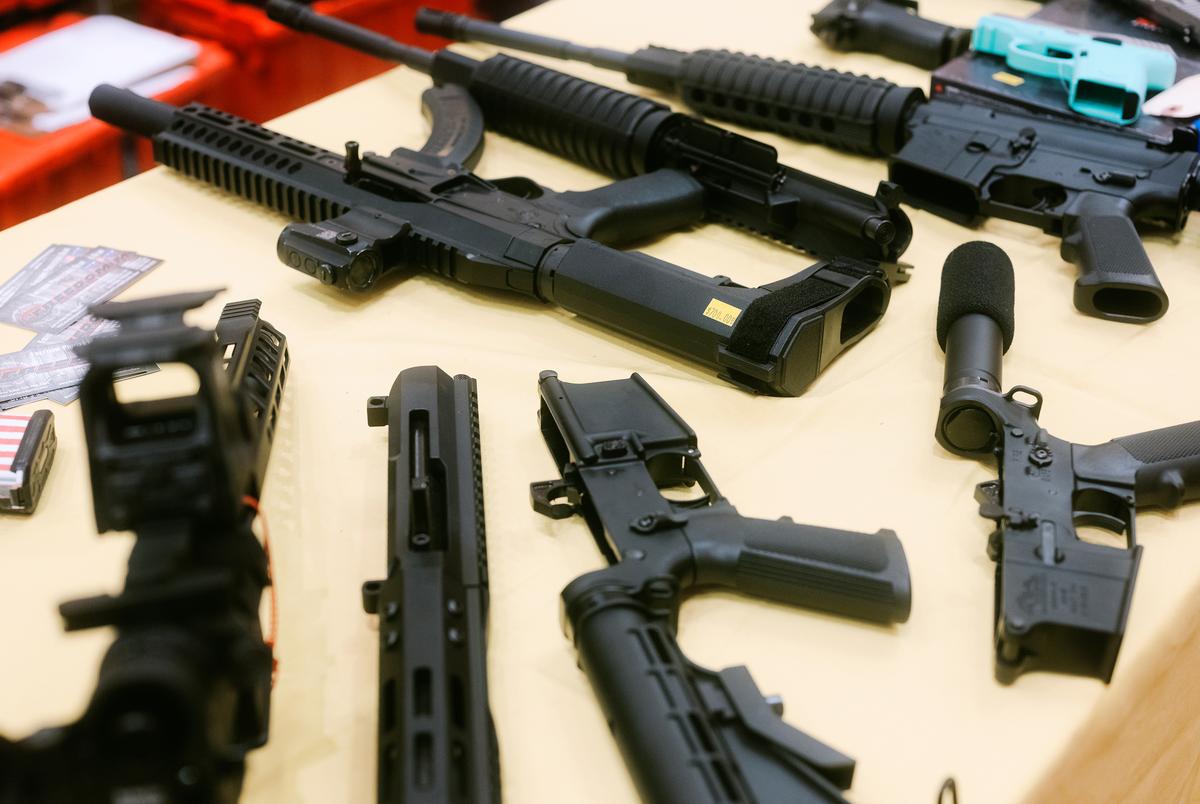 Assault-style weapons are laid on a table at a gun show in San Marcos on Sunday, Jan. 29, 2023.