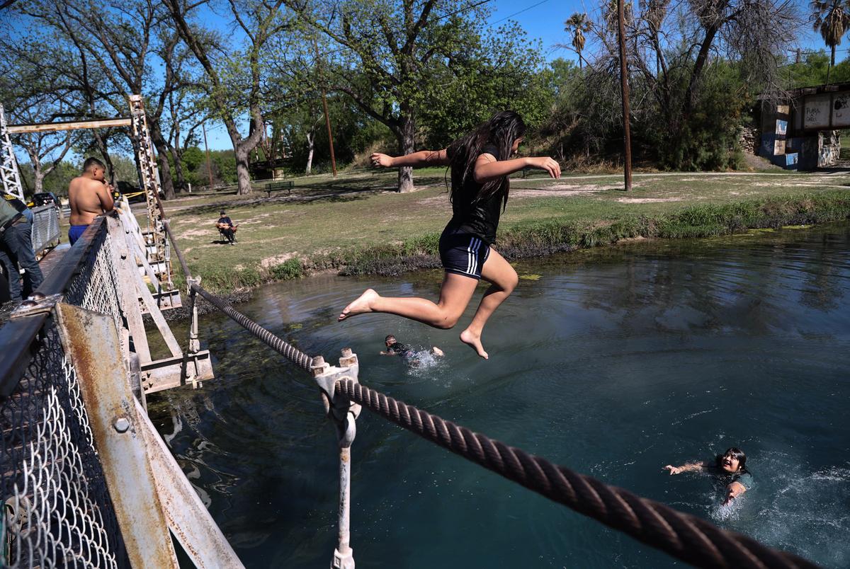 Ameliaña Treviño jumps off of a suspension bridge at Blue Hole Park in Del Rio on March 25, 2023.