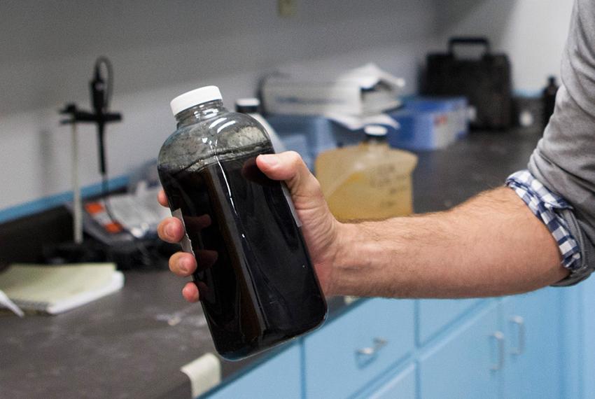 Omni Water Solutions chemist, Billy Roberts, holding a bottle of used fracking water from an active gas well. The polluted water is pungent and toxic but once Omni Water Solutions cleans the water it is drinkable.