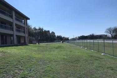 A temporary fence erected around the quarantined hotel on Lackland Air Force Base.