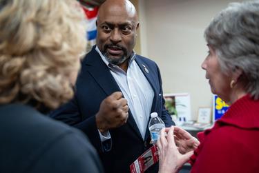 KCarl Smith speaks to Terry McDonald, left, and Pam Archer before a 