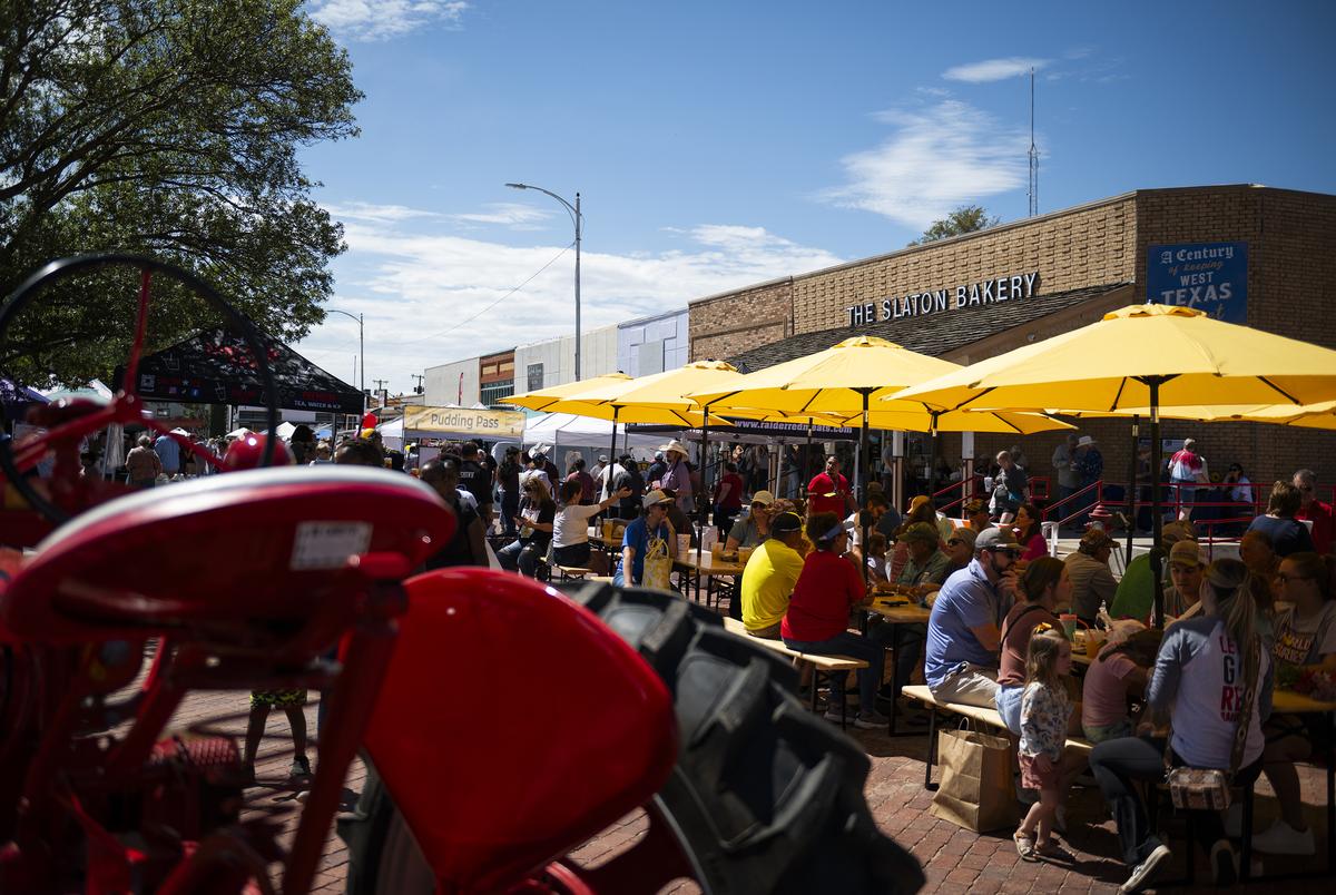 Festival attendees sit outside the Slaton Bakery at the Texas Banana Pudding Festival Saturday, Aug. 30, 2025, in Slaton, Texas.