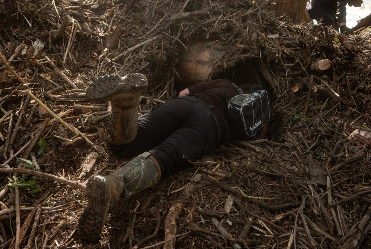 A sheriff deputy looks into a nook under the debris from the flood during search and recovery in Center Point on Tuesday July 8, 2025.