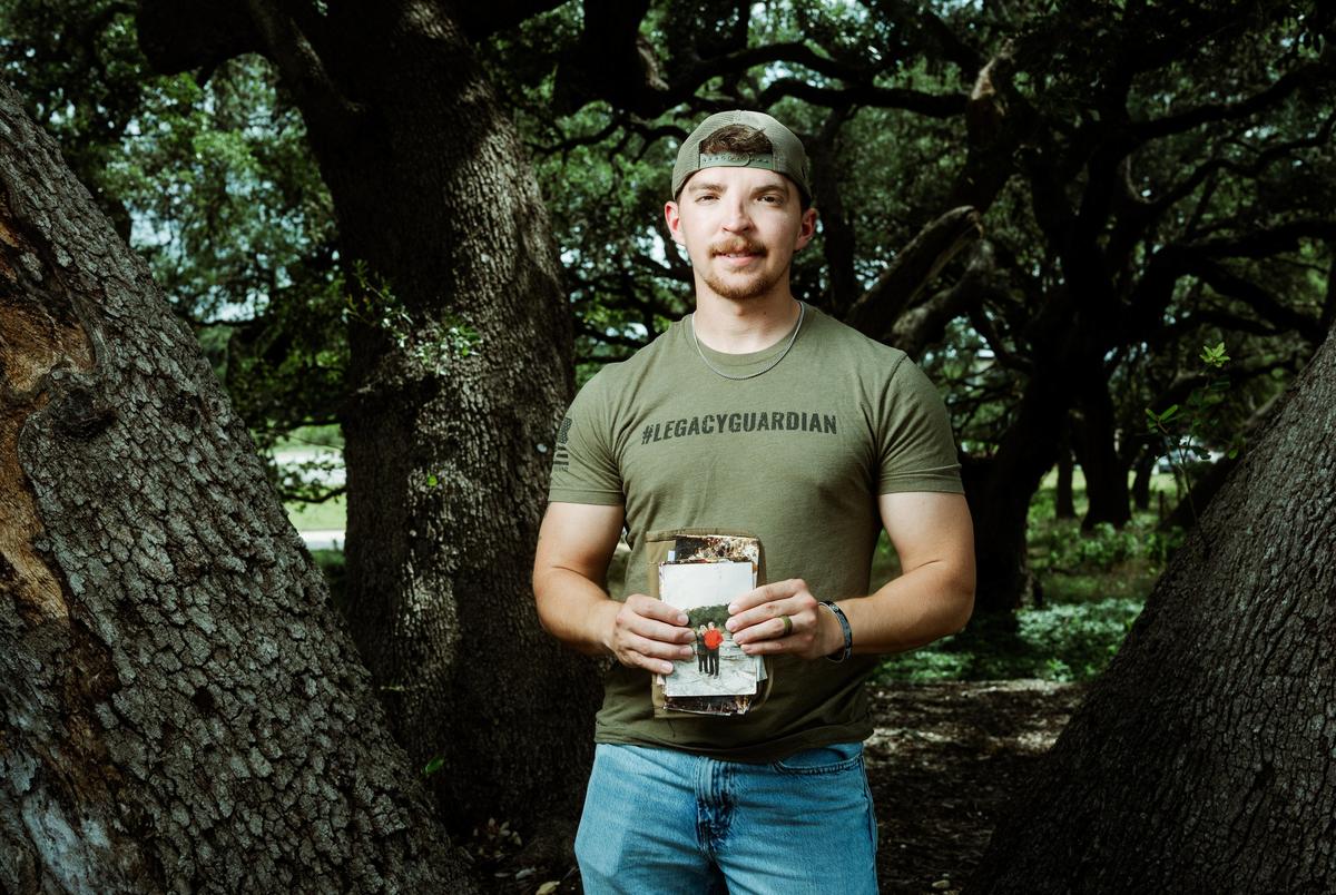 Michael Guyer holds photos and patches from the Heart of the Hills camp that he has found while volunteering in search efforts in the aftermath of the flood in Kerr County.