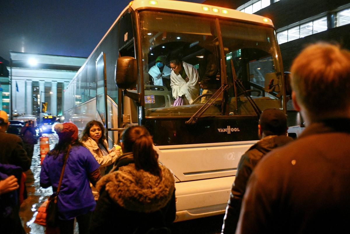 Migrants transported from the U.S. border arrive on a bus from Texas and are taken by city officials to wait for relocation, in Philadelphia, Pennsylvania on November 16, 2022.