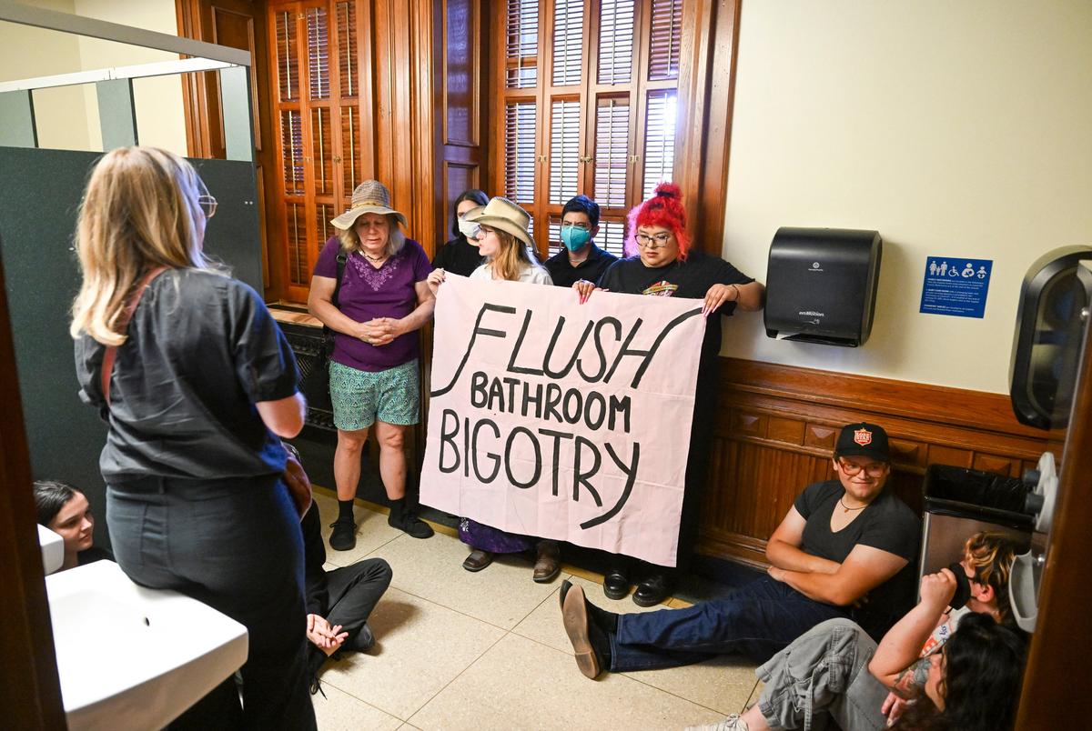 Activists from Trans Texas occupy the women's restroom on the first floor of the Texas Capitol after the House State Affairs Committe heard testimony on the 